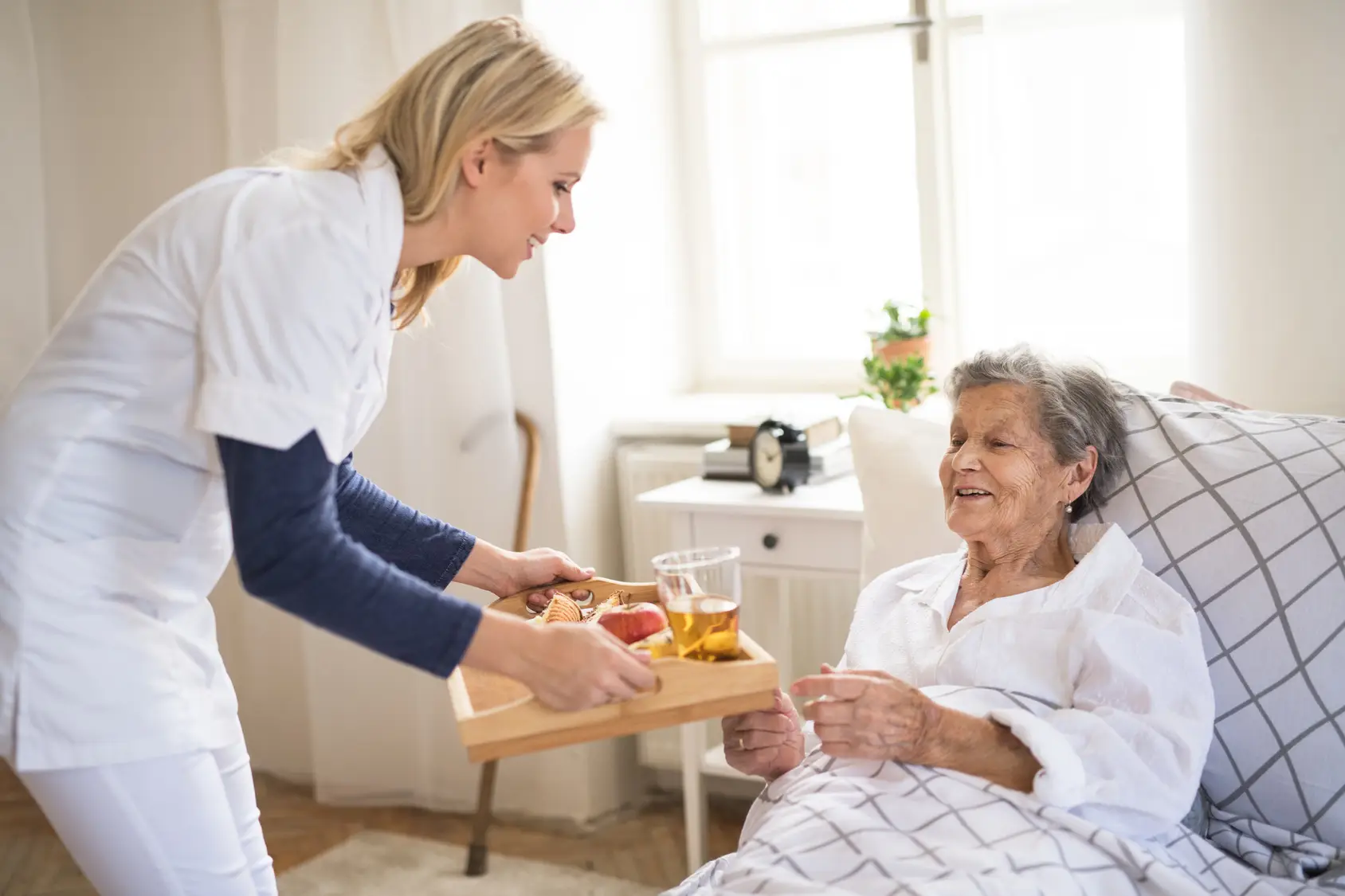http://elderly%20senior%20being%20brought%20meal%20by%20carer%20or%20nurse